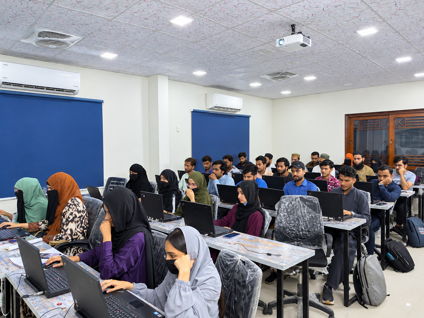 Students learning practical computer skills in the AGHA Institute computer lab